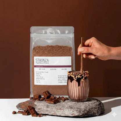 Chocolate plant-based protein powder with chocolate chunks and a chocolate smoothie in a glass.